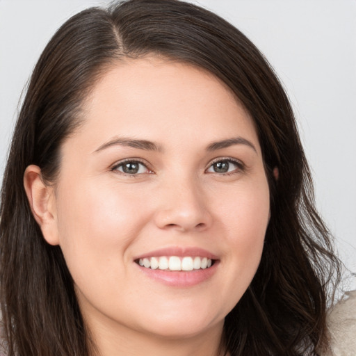 Joyful white young-adult female with long  brown hair and brown eyes