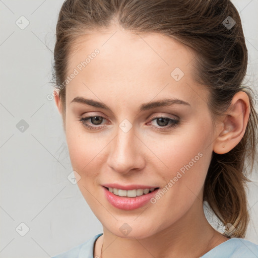 Joyful white young-adult female with medium  brown hair and grey eyes