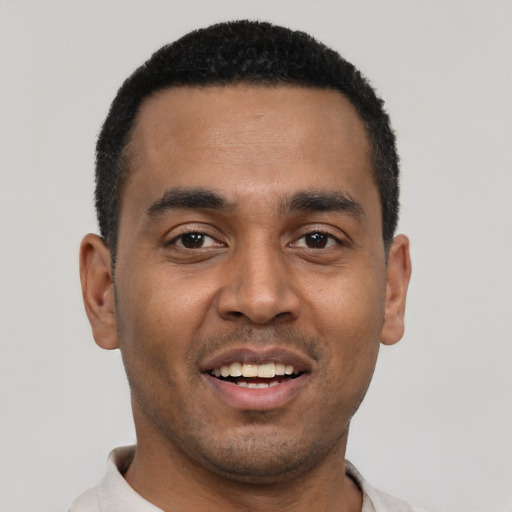 Joyful black young-adult male with short  black hair and brown eyes