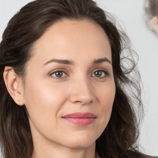 Joyful white young-adult female with long  brown hair and brown eyes