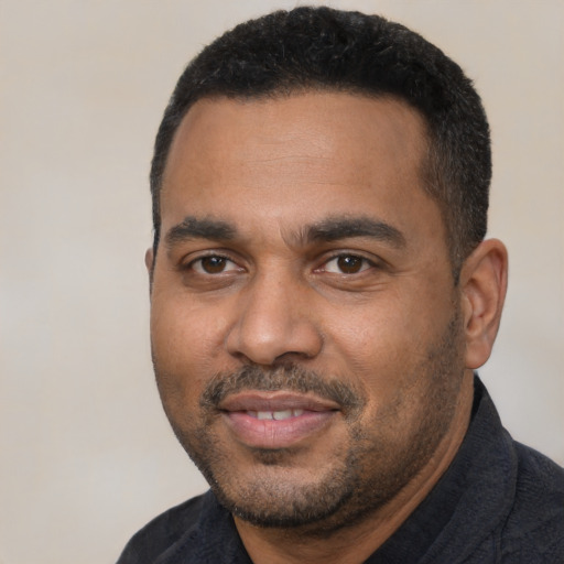Joyful black adult male with short  black hair and brown eyes