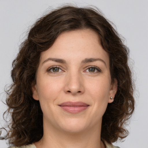 Joyful white young-adult female with medium  brown hair and green eyes