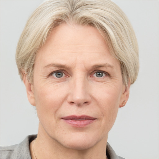 Joyful white adult female with short  blond hair and grey eyes