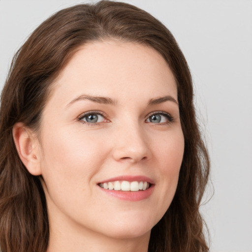 Joyful white young-adult female with long  brown hair and blue eyes