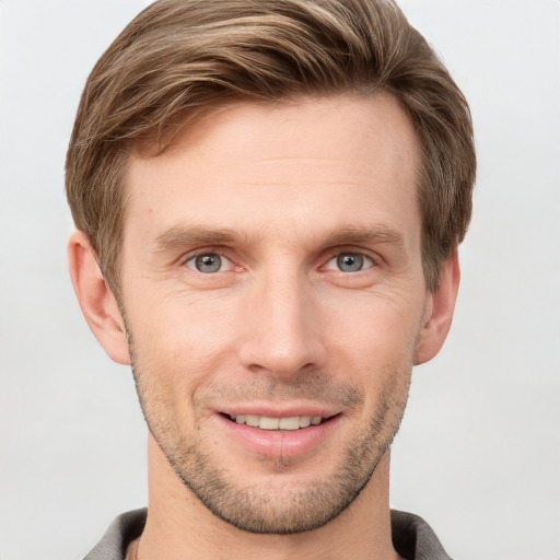 Joyful white young-adult male with short  brown hair and grey eyes