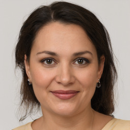 Joyful white adult female with medium  brown hair and brown eyes