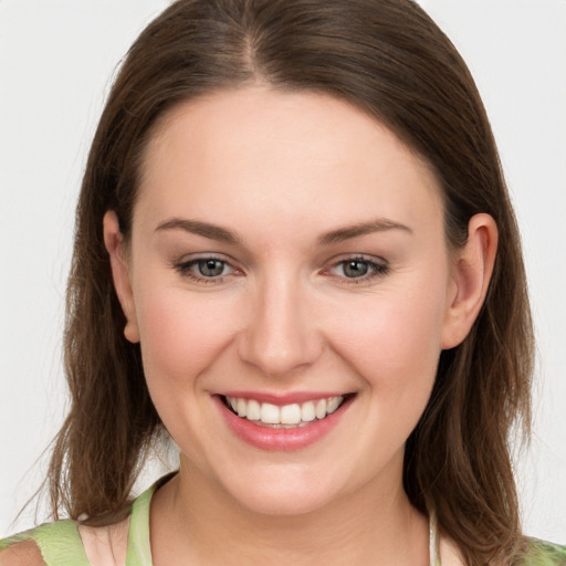 Joyful white young-adult female with medium  brown hair and green eyes