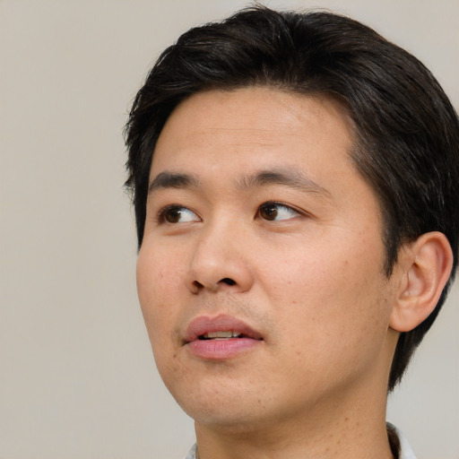 Neutral asian adult male with short  brown hair and brown eyes