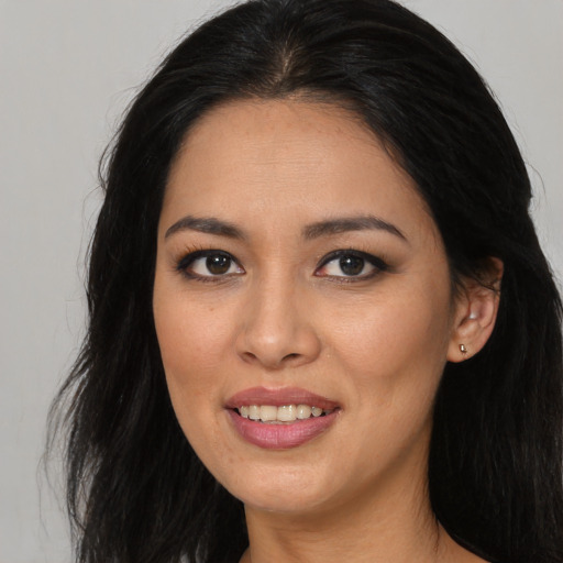 Joyful asian young-adult female with long  brown hair and brown eyes