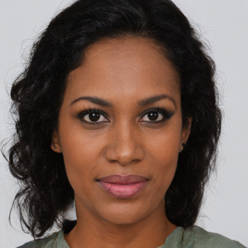 Joyful black young-adult female with long  brown hair and brown eyes