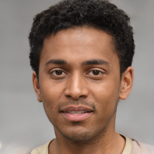 Joyful black young-adult male with short  black hair and brown eyes