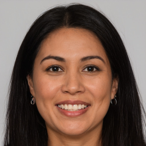 Joyful latino young-adult female with long  brown hair and brown eyes