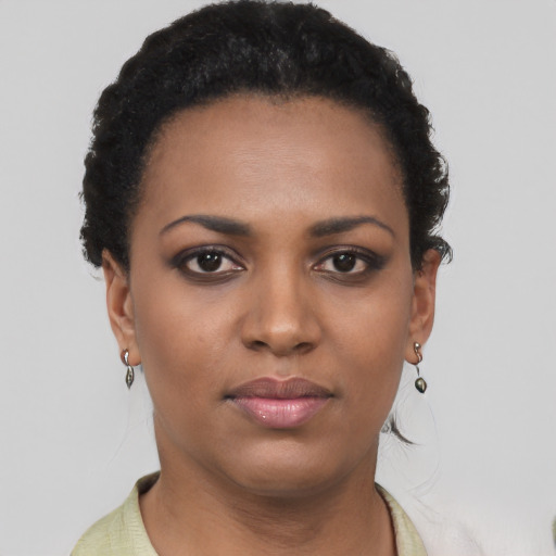 Joyful black young-adult female with short  brown hair and brown eyes