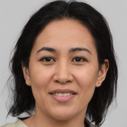 Joyful asian adult female with medium  brown hair and brown eyes