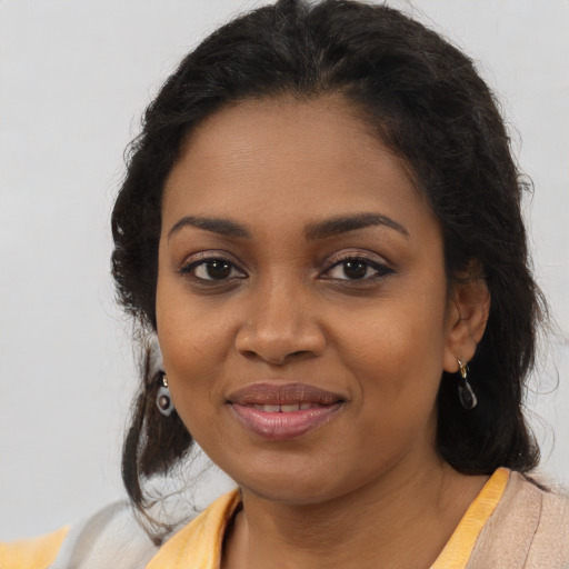 Joyful black young-adult female with long  brown hair and brown eyes