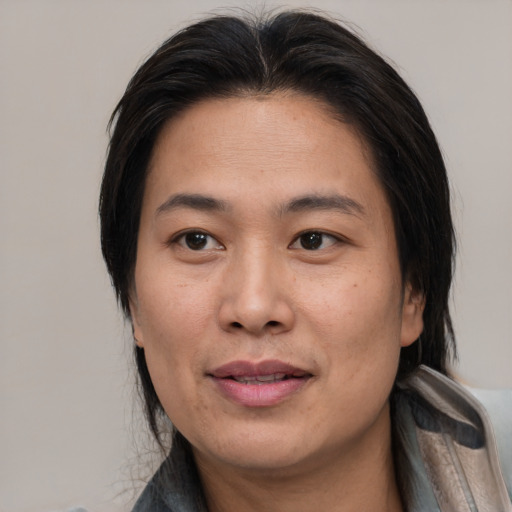Joyful asian adult female with medium  brown hair and brown eyes