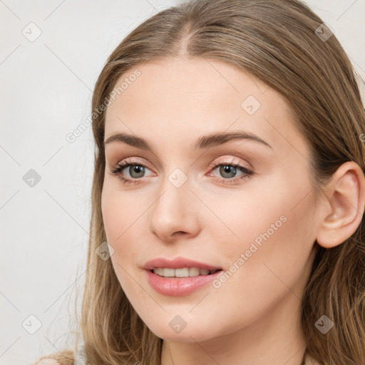 Joyful white young-adult female with long  brown hair and blue eyes