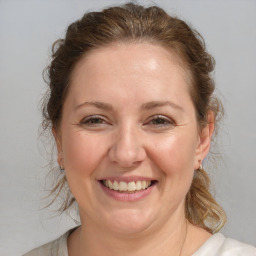 Joyful white adult female with medium  brown hair and blue eyes