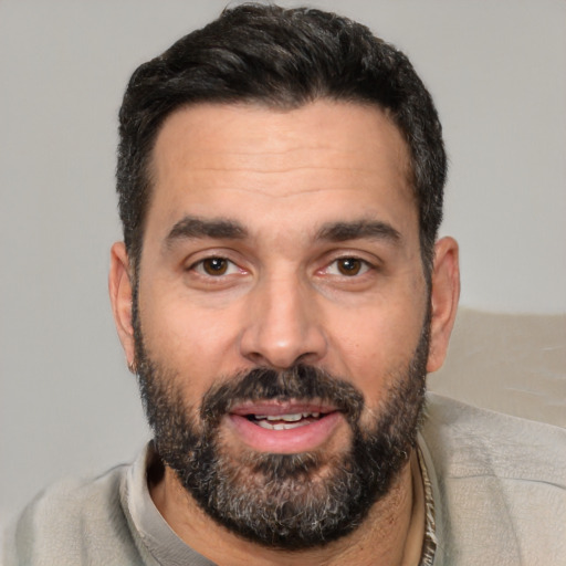 Joyful white adult male with short  black hair and brown eyes