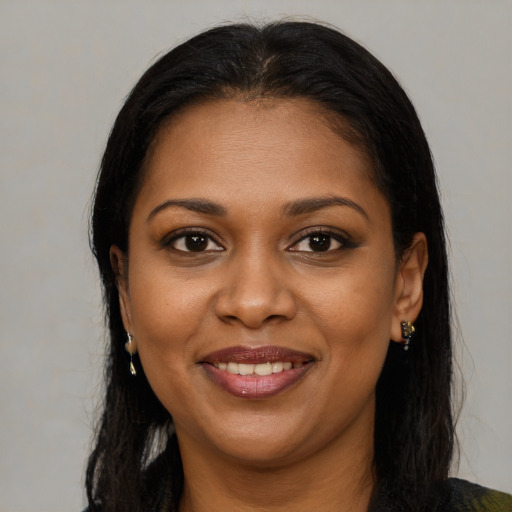 Joyful black young-adult female with long  brown hair and brown eyes