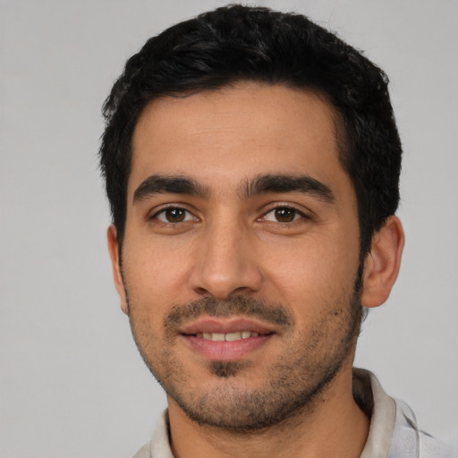 Joyful latino young-adult male with short  black hair and brown eyes