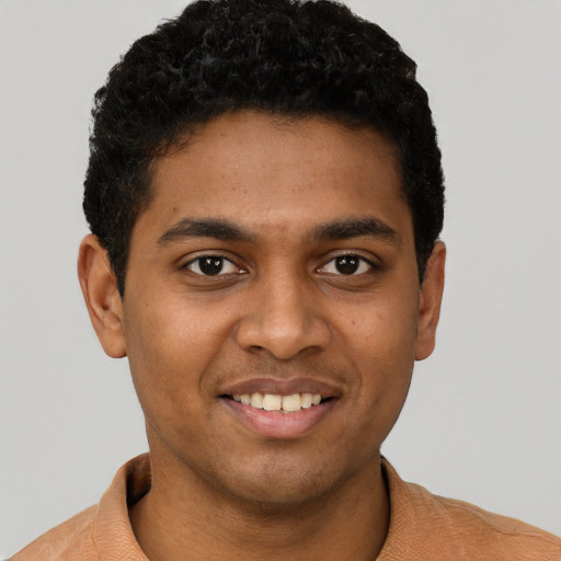 Joyful black young-adult male with short  black hair and brown eyes