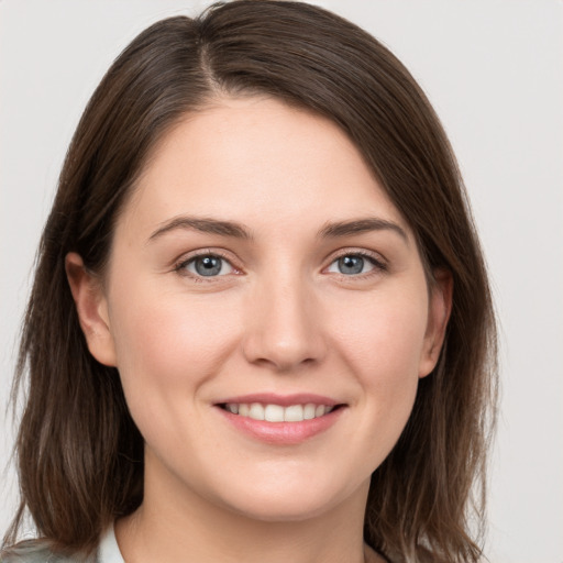 Joyful white young-adult female with medium  brown hair and grey eyes