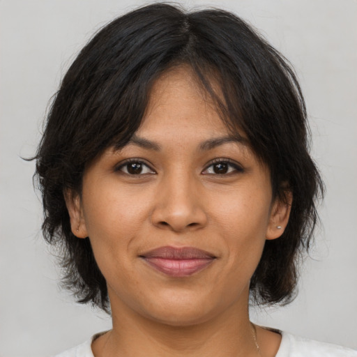 Joyful latino young-adult female with medium  brown hair and brown eyes