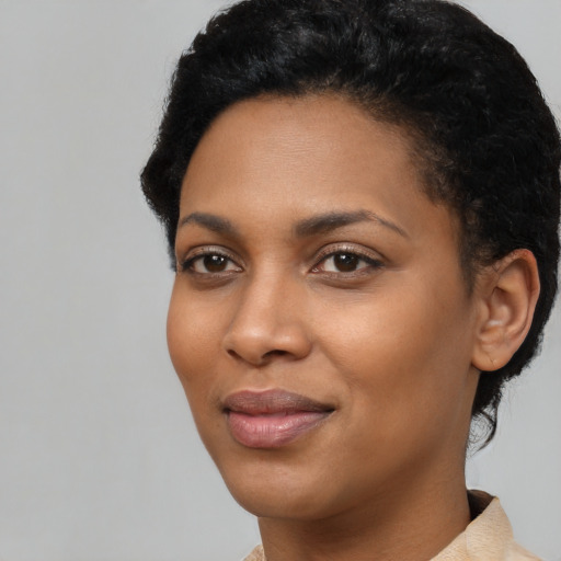 Joyful black young-adult female with short  black hair and brown eyes