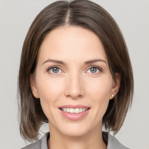 Joyful white young-adult female with medium  brown hair and grey eyes