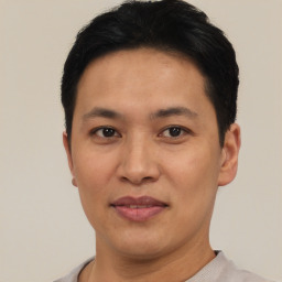 Joyful asian young-adult male with short  black hair and brown eyes