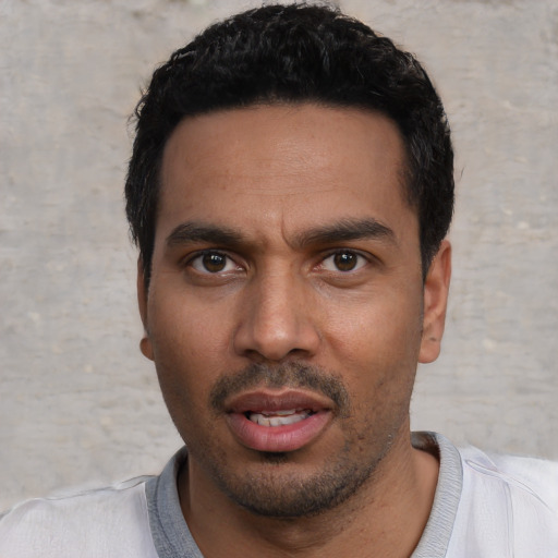 Joyful white young-adult male with short  black hair and brown eyes