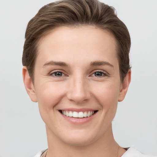 Joyful white young-adult female with short  brown hair and grey eyes