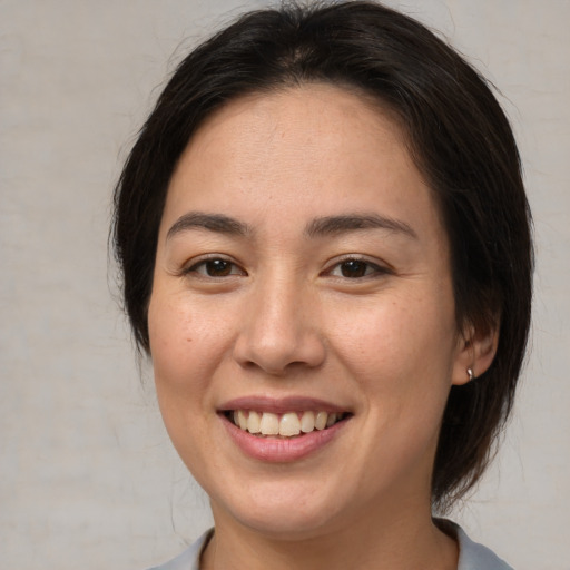 Joyful asian young-adult female with medium  brown hair and brown eyes