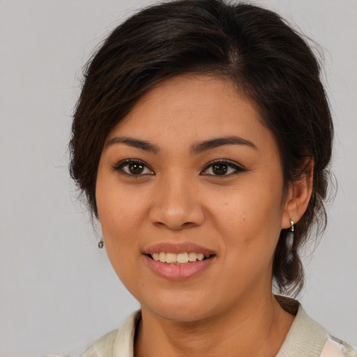 Joyful latino young-adult female with medium  brown hair and brown eyes