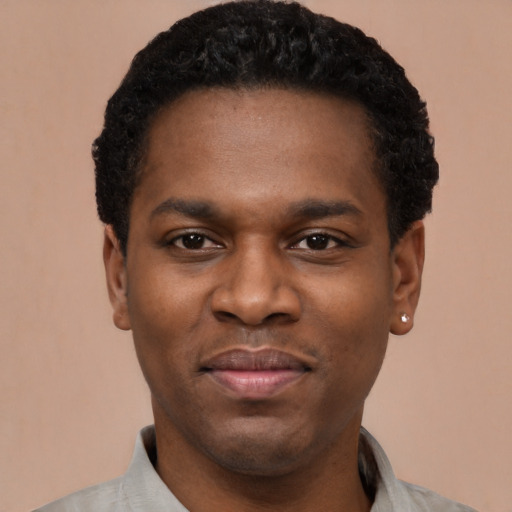 Joyful black young-adult male with short  black hair and brown eyes