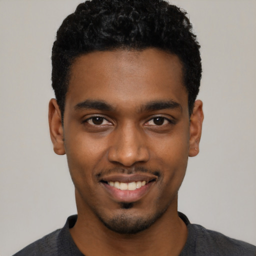 Joyful black young-adult male with short  black hair and brown eyes