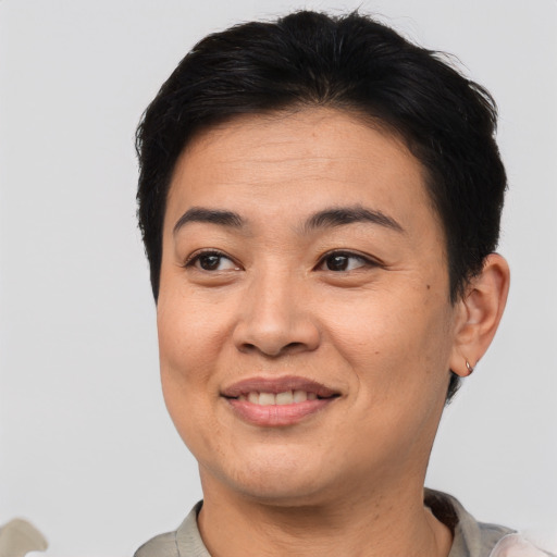 Joyful asian adult female with short  brown hair and brown eyes