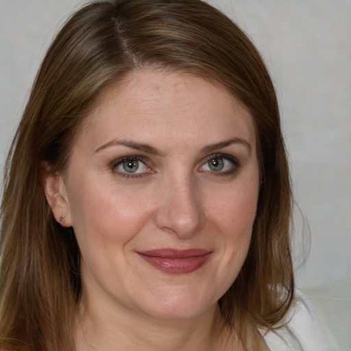 Joyful white adult female with long  brown hair and grey eyes