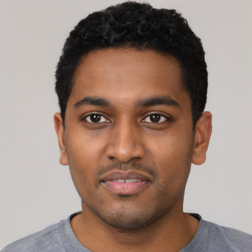 Joyful black young-adult male with short  black hair and brown eyes