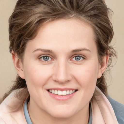 Joyful white young-adult female with medium  brown hair and blue eyes