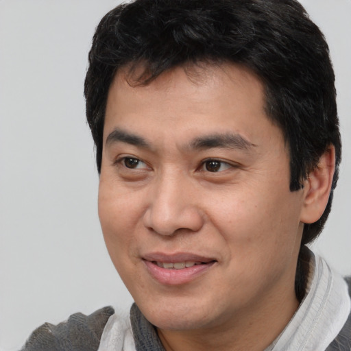 Joyful asian young-adult male with short  brown hair and brown eyes