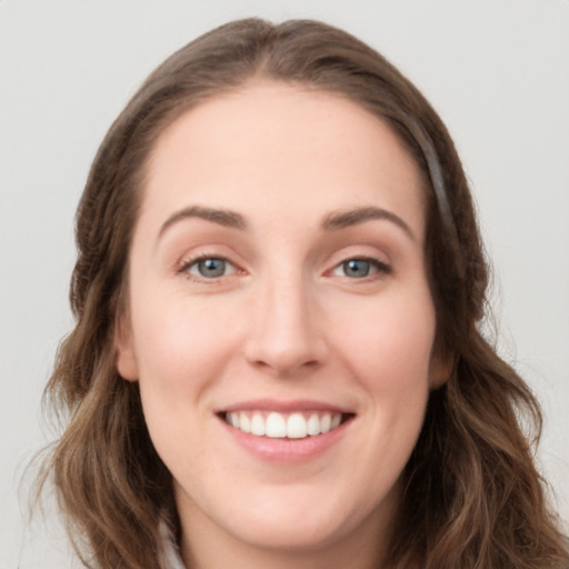 Joyful white young-adult female with long  brown hair and green eyes