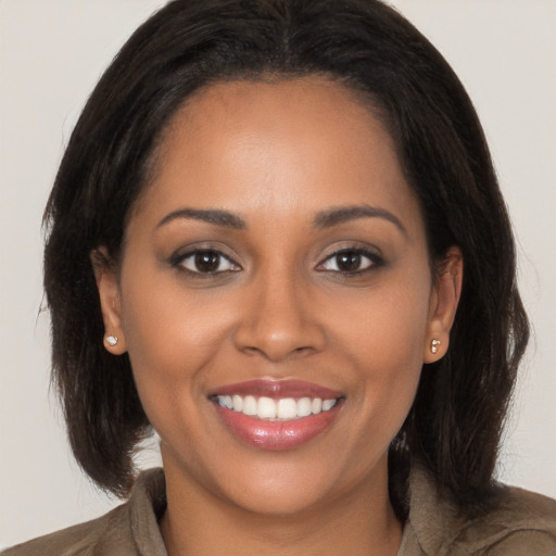 Joyful black young-adult female with long  brown hair and brown eyes