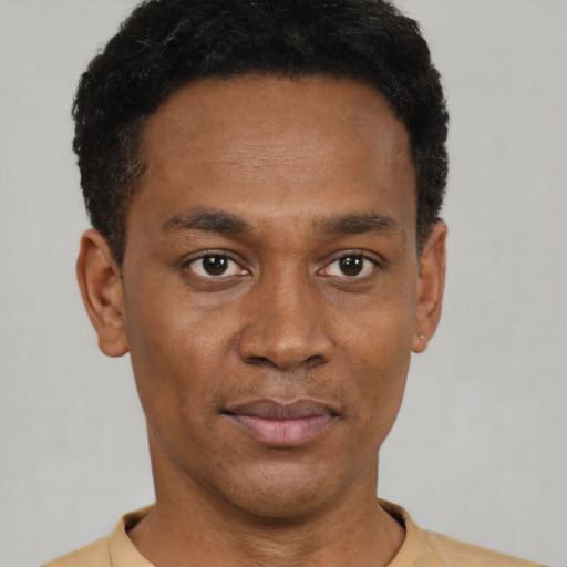 Joyful black young-adult male with short  black hair and brown eyes