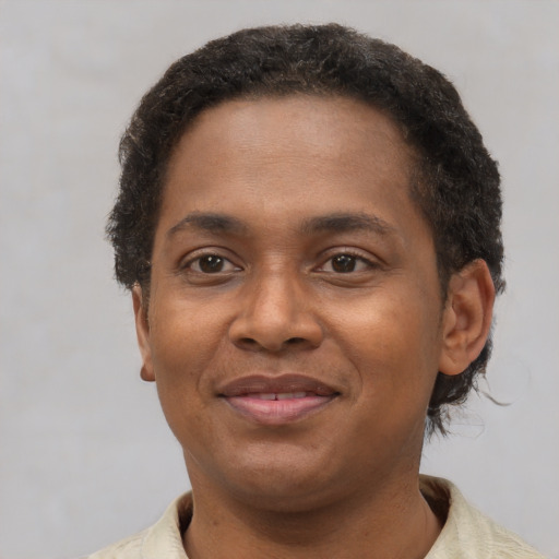 Joyful black adult female with short  brown hair and brown eyes