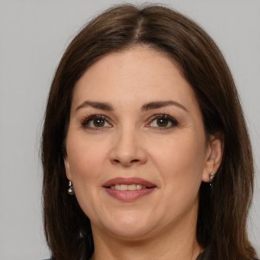 Joyful white adult female with long  brown hair and brown eyes