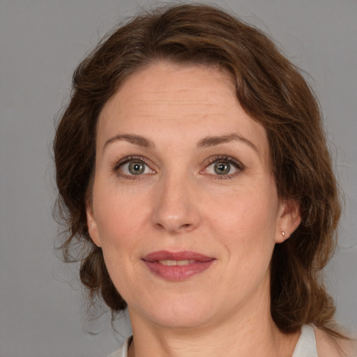 Joyful white adult female with medium  brown hair and green eyes