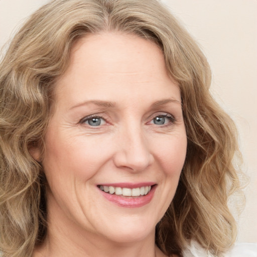 Joyful white adult female with medium  brown hair and blue eyes