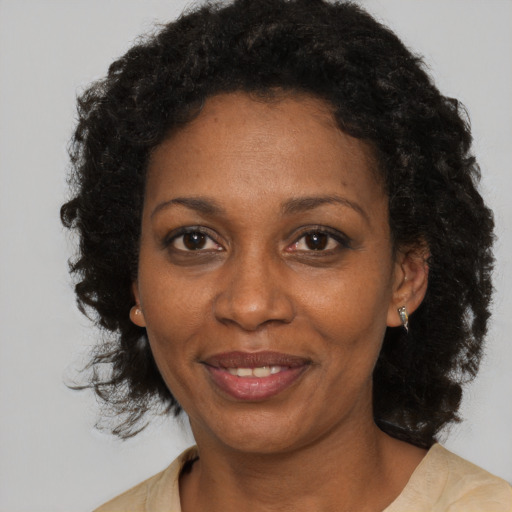 Joyful black adult female with medium  brown hair and brown eyes